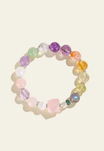 Vista detallada de una pulsera de cuentas de cristal natural con una piedra rosa.