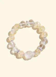 Primer plano de pulsera de cuentas de citrino y cuarzo blanco con dije de tortuga dragón