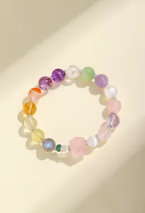 Detalle macro exquisito de una pulsera de piedras naturales con cuarzo rosa y amatista.