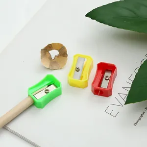 Close-up of colorful plastic pencil sharpeners with pencil shavings on white background.