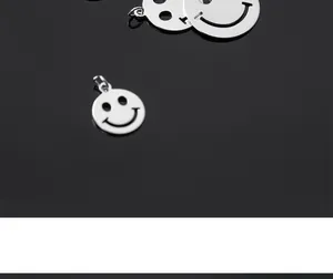 Detailed close-up of hollow S925 sterling silver smiley face charms for DIY jewelry