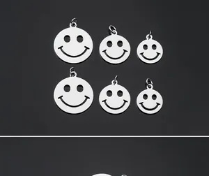 Macro view of multiple sizes of stainless steel smiling face pendants for jewelry DIY