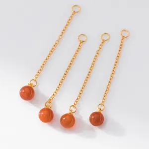 Close-up of 925 silver gold-plated cross chains with red agate bead charms for jewelry DIY.