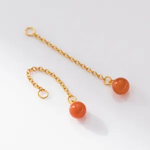 Close-up of gold-plated silver cross chains with round red agate beads for DIY earrings