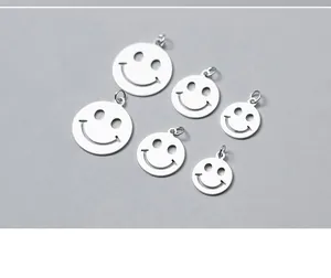 Close-up of six different sizes of sterling silver hollow smiley face pendants