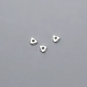 Close-up macro shot of 925 sterling silver geometric triangle spacer beads for DIY