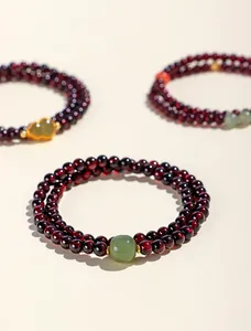 Detailansicht eines eleganten doppelreihigen Armbands aus Granatperlen mit Jade-Akzent