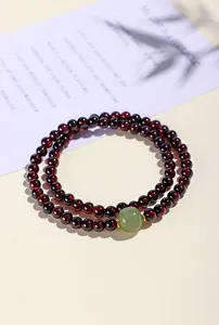 Detailansicht eines zweireihigen Granat-Perlenarmbands mit hellgrünem Jadestein