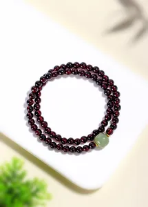Detail eines doppellagigen Granatarmbands mit einem Akzent aus grüner Jade.