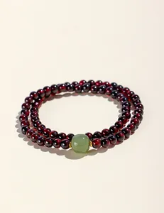 Detailansicht eines zweireihigen Naturgranat-Perlenarmbands mit blassgrüner Jadeperle