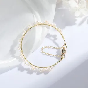 Close-up of hand-woven freshwater pearl bracelet with gold-plated wire and magnetic clasp