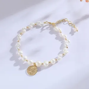 Detail view of a handcrafted freshwater pearl bracelet with a golden coin pendant