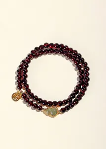 Nahaufnahme eines dunkelroten Granat-Doppelstrang-Armbands mit Jade-Anhänger in Kürbisform