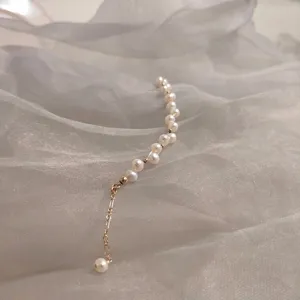 Elegant freshwater pearl bracelet with adjustable gold chain on soft grey fabric