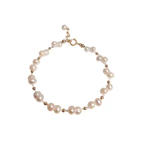 Handmade freshwater pearl bracelet with gold spacer beads on white background