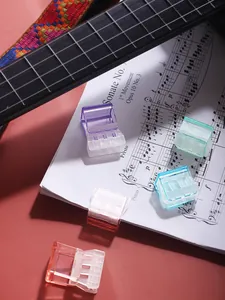 Gedetailleerde macro-opname van kleurrijke doorschijnende klemmen op een muziekblad