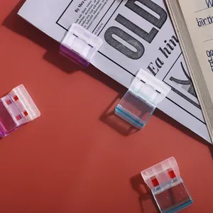 Gekleurde gelei-kleurige kantoorclips weergegeven op een rode achtergrond met papier