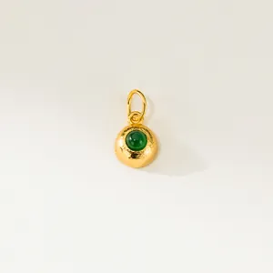 Vue macro détaillée d'un pendentif en argent 925 doré avec une émeraude ronde verte