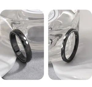 Close-up detail of a minimalist black faceted ceramic ring showing elegant texture and finish.