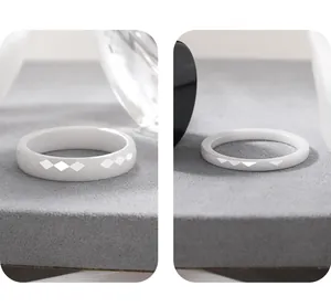 Detailed close-up view of white ceramic rings with elegant diamond-cut faceted designs