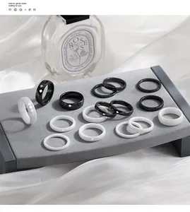 Detailed view of black and white ceramic rings with diamond patterns and plain bands.