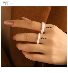 Close-up of 3mm and 4mm white faceted ceramic rings on model's hand.