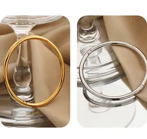Split view of minimalist titanium steel bangles in polished gold and silver finishes.