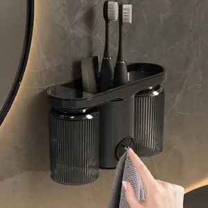 Moderne tandenborstelhouder voor wandmontage met twee grijze bekers en handdoekplug.