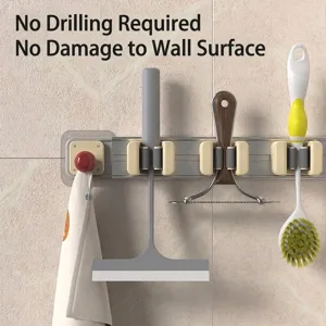 Wall-mounted mop and broom holder with sliding clips and hook, no drilling required