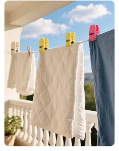 Wide multi-functional plastic laundry clips holding quilts on an outdoor clothesline