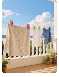 Large colorful plastic laundry clips securing clothes on a sunny balcony clothesline.