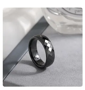 Macro view of a faceted black ceramic ring showing the reflective mirror finish detail
