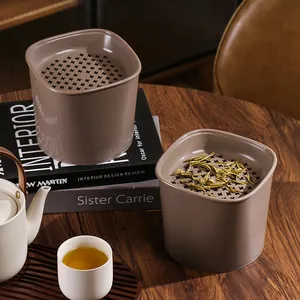 Detail of desktop tea dregs filter trash can with star-shaped strainer on wooden table