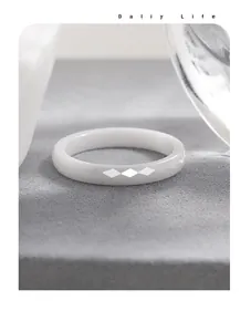 Detailed view of a white ceramic minimalist ring with a faceted rhombus geometric design