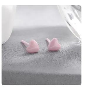 Macrodetail van schattige roze hartvormige biokeramische oorknopjes voor gevoelige oren