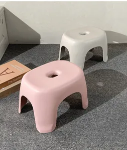 Taburetes de plástico modernos en rosa y gris en un ambiente doméstico minimalista
