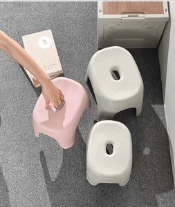 Vista superior de taburetes de plástico rosa y blanco con asas cómodas