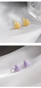 Detailopname van minimalistische hartvormige bioceramische oorbellen in geel en paars