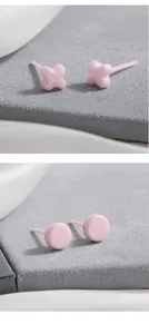 Detail van roze biokeramische oorknopjes in ronde vorm en in de vorm van een klaver.