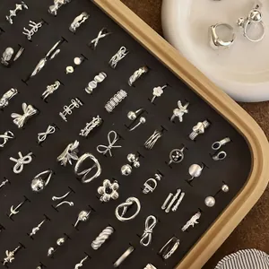 Detailed view of various 925 sterling silver minimalist rings in a wooden display tray.