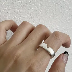 Close-up detail of a 925 sterling silver minimalist wavy open ring on a finger
