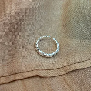 Close-up detail of a 925 sterling silver twisted rope ring on fabric background.