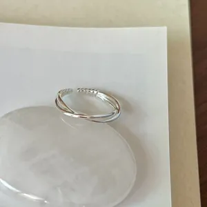 Close-up of a minimalist 925 sterling silver intertwined open ring for women