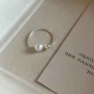 Detail of minimalist 925 sterling silver open ring with frosted and polished beads.