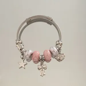 Vue détaillée d'un bracelet à breloques en acier inoxydable avec perles roses.