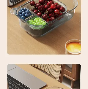 Detailed view of a divided clear grey food storage box with fresh cherries and grapes.