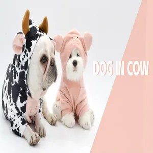 Detailed shot of two small dogs wearing adorable cow and pink pig plush costumes