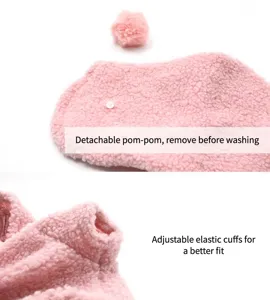 Close-up of pink fuzzy pet clothes showing detachable pom-pom and elastic cuff detail