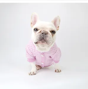 Detailed view of a French Bulldog wearing a stylish pink tweed cardigan dog sweater