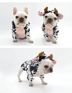 Cute French Bulldog in black and white cow print pet costume with small horns detail.